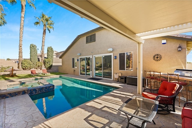 view of pool featuring a patio and an in ground hot tub