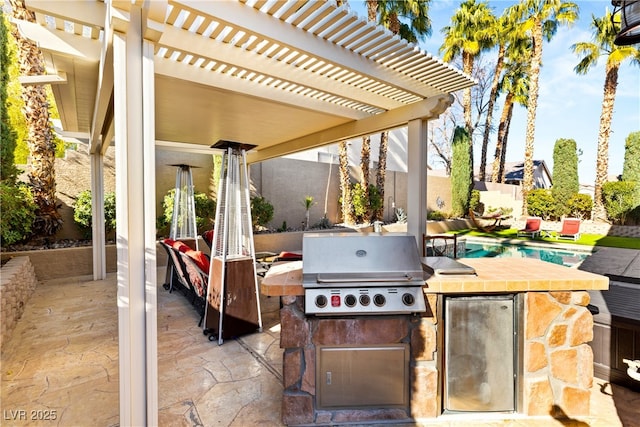 view of patio / terrace featuring area for grilling, a pergola, and exterior kitchen