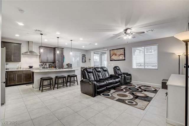 tiled living room featuring ceiling fan and sink