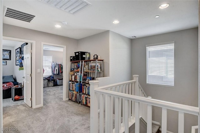 hall with light colored carpet