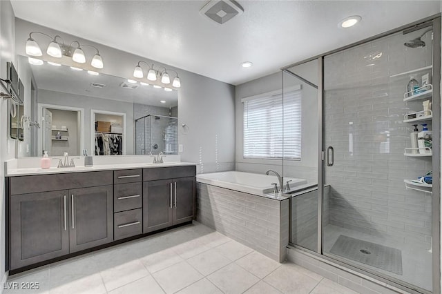 bathroom with tile patterned flooring, plus walk in shower, and vanity