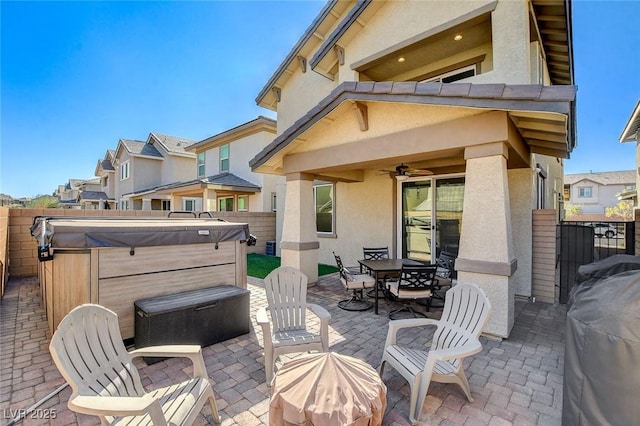 view of patio with ceiling fan, a hot tub, and area for grilling