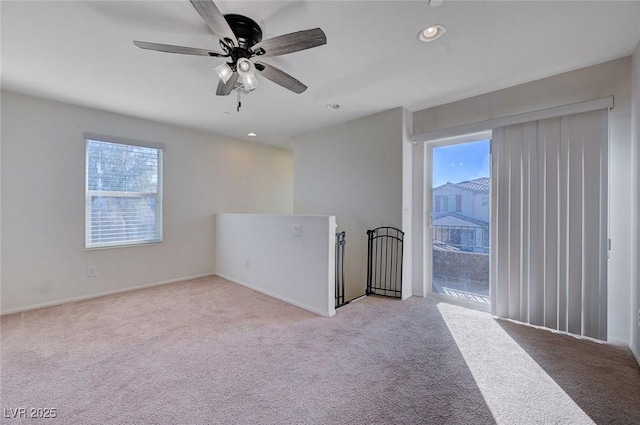 empty room featuring a healthy amount of sunlight, light colored carpet, and ceiling fan