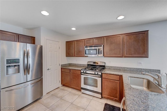 kitchen featuring light tile patterned flooring, appliances with stainless steel finishes, and sink