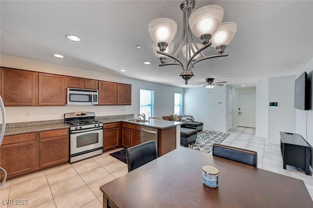 kitchen featuring sink, hanging light fixtures, stainless steel appliances, light tile patterned flooring, and kitchen peninsula