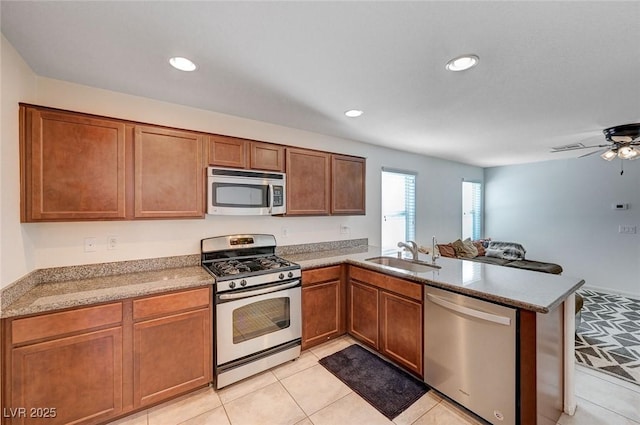 kitchen featuring stainless steel appliances, kitchen peninsula, sink, and light tile patterned floors