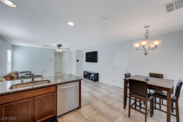 kitchen featuring light tile patterned floors, sink, dishwasher, hanging light fixtures, and ceiling fan with notable chandelier