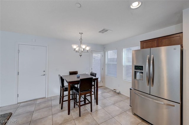 tiled dining area featuring an inviting chandelier