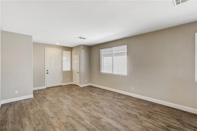 empty room featuring hardwood / wood-style floors and a textured ceiling