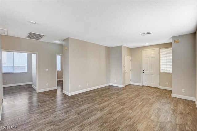 unfurnished room with plenty of natural light and hardwood / wood-style floors