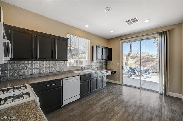 kitchen featuring tasteful backsplash, dark hardwood / wood-style flooring, sink, and white appliances