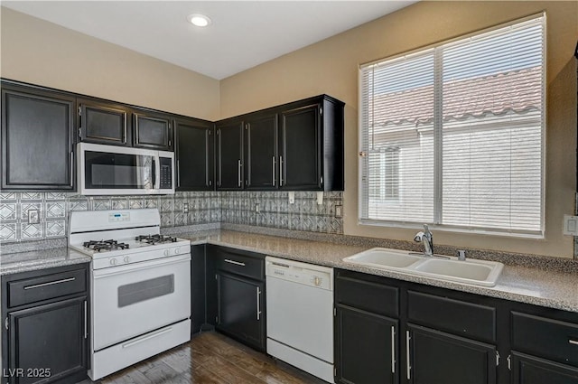 kitchen with sink, dark wood-type flooring, white appliances, and decorative backsplash