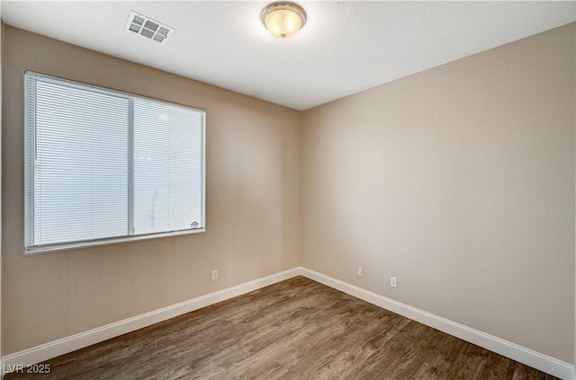 spare room featuring wood-type flooring