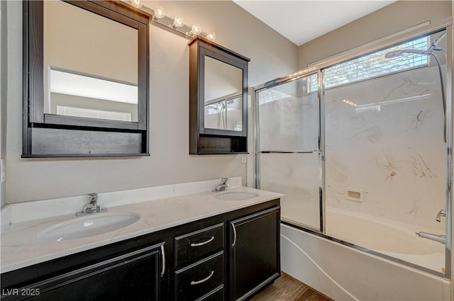 bathroom featuring hardwood / wood-style flooring, vanity, and shower / bath combination with glass door