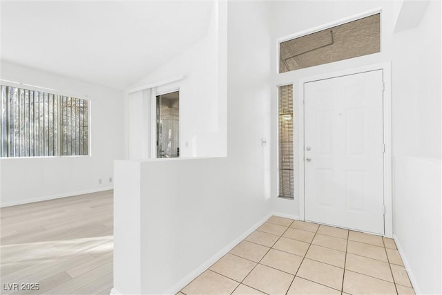 entrance foyer featuring light tile patterned floors and vaulted ceiling