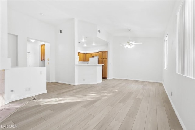 unfurnished living room featuring ceiling fan and light hardwood / wood-style flooring