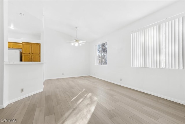 unfurnished living room with ceiling fan, lofted ceiling, and light wood-type flooring