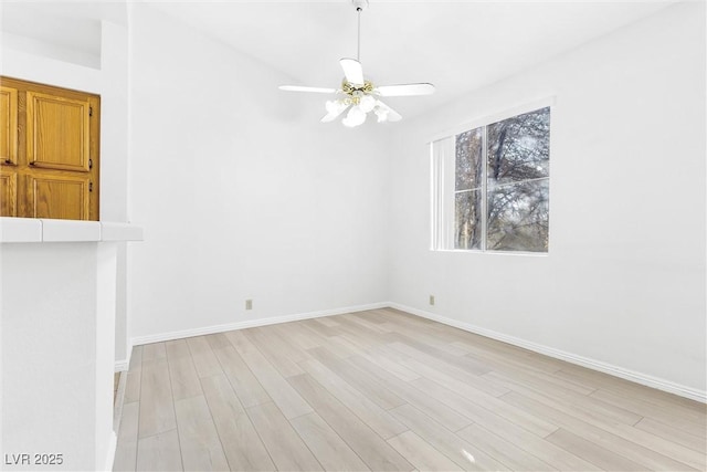 empty room with ceiling fan and light hardwood / wood-style flooring