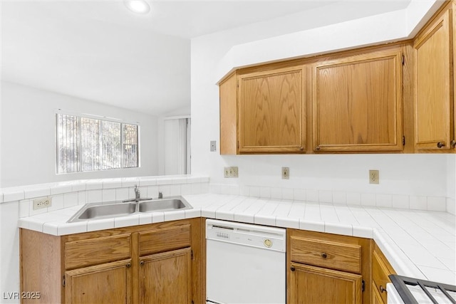 kitchen with sink, range, tile countertops, white dishwasher, and kitchen peninsula