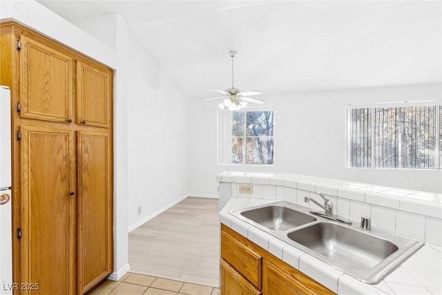 kitchen featuring a wealth of natural light, sink, and tile counters