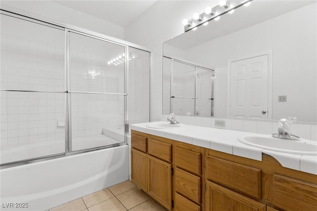 bathroom with enclosed tub / shower combo, tile patterned floors, and vanity