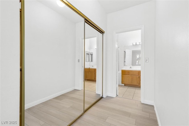 corridor with sink and light hardwood / wood-style floors