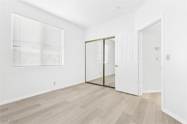 unfurnished bedroom with light hardwood / wood-style flooring and a closet