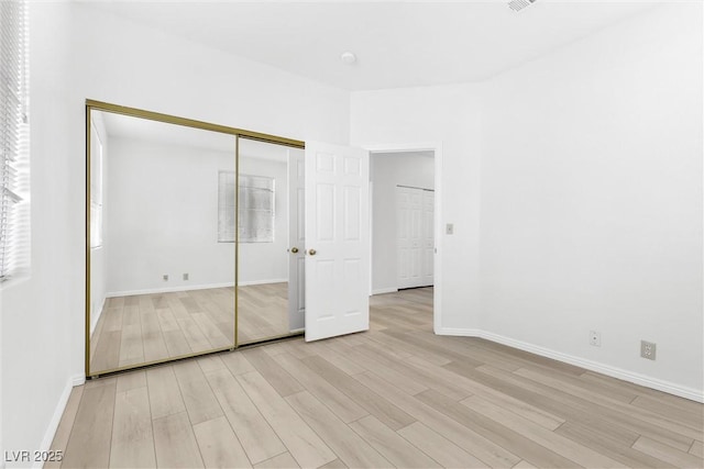 unfurnished bedroom featuring a closet and light wood-type flooring