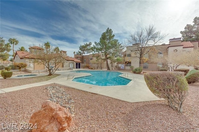 view of pool with a hot tub and a patio