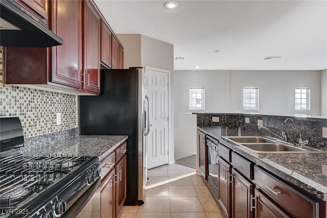 kitchen featuring sink, dark stone countertops, tasteful backsplash, black appliances, and light tile patterned flooring