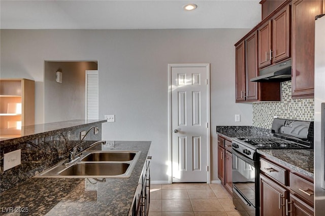 kitchen with light tile patterned flooring, sink, decorative backsplash, dark stone counters, and black gas range