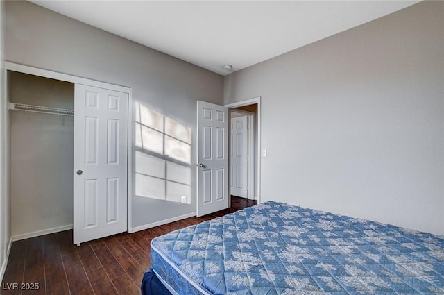 bedroom with dark hardwood / wood-style floors and a closet