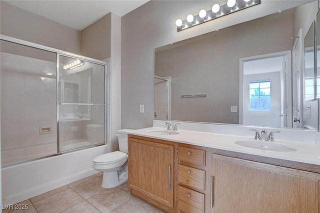 full bathroom featuring enclosed tub / shower combo, tile patterned floors, toilet, and vanity