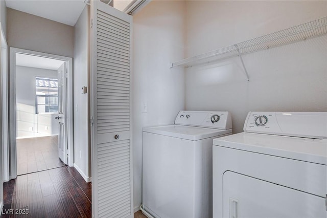 clothes washing area with dark wood-type flooring and washing machine and clothes dryer