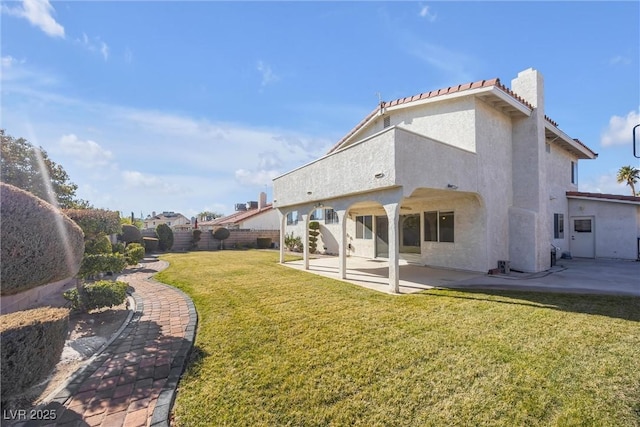 rear view of house featuring a yard and a patio area