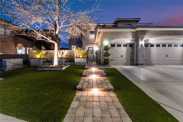 view of front of home with a garage and a yard