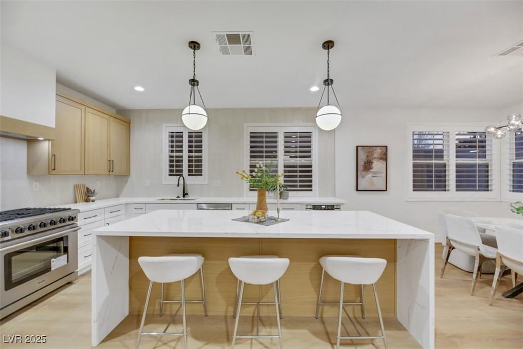 kitchen with sink, hanging light fixtures, a center island, and appliances with stainless steel finishes