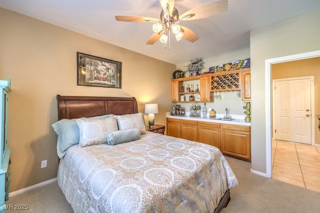 carpeted bedroom with wet bar and ceiling fan