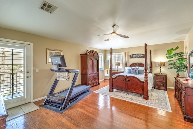 bedroom featuring multiple windows, access to outside, and light hardwood / wood-style floors