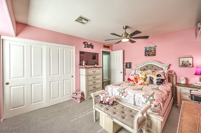 bedroom with light colored carpet, ceiling fan, and a closet