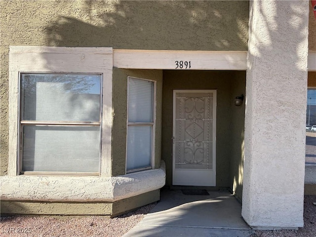 entrance to property with stucco siding