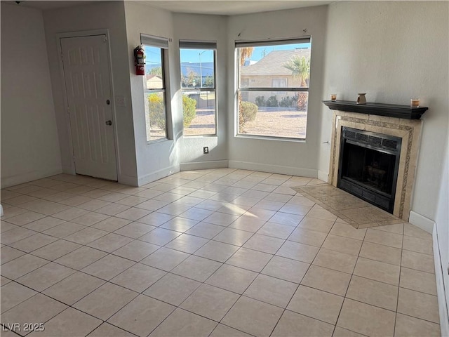 unfurnished living room with light tile patterned floors, baseboards, and a fireplace