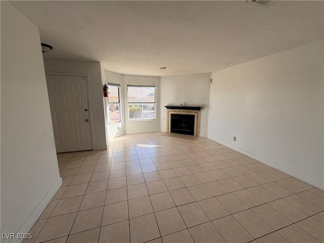 unfurnished living room with light tile patterned floors, visible vents, a fireplace, and baseboards