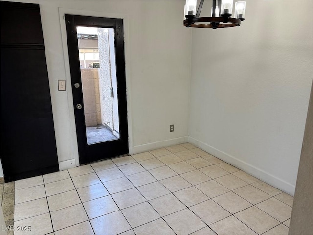 interior space with light tile patterned floors, baseboards, and a notable chandelier