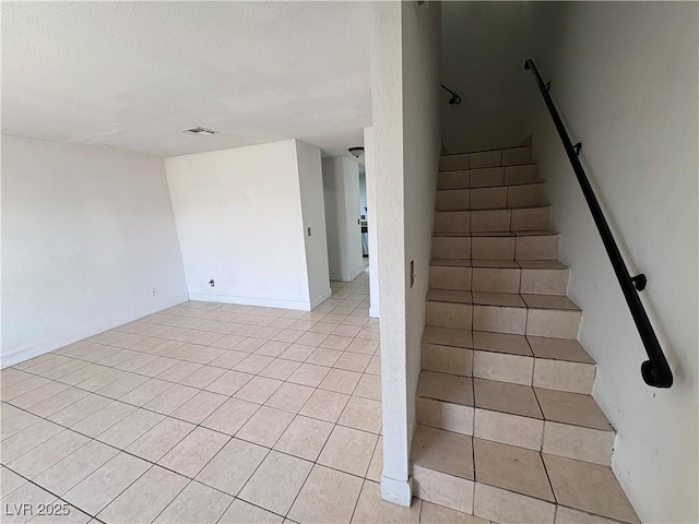 stairs featuring tile patterned floors, visible vents, and baseboards