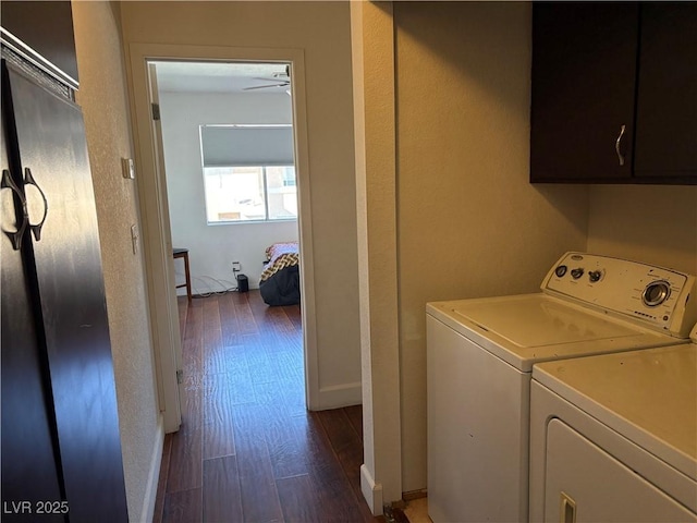 clothes washing area with wood finished floors, cabinet space, separate washer and dryer, and baseboards