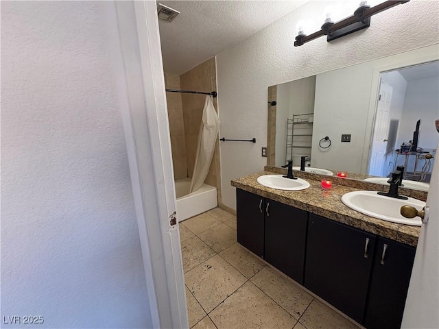 bathroom featuring a sink, visible vents, a textured ceiling, and tile patterned floors