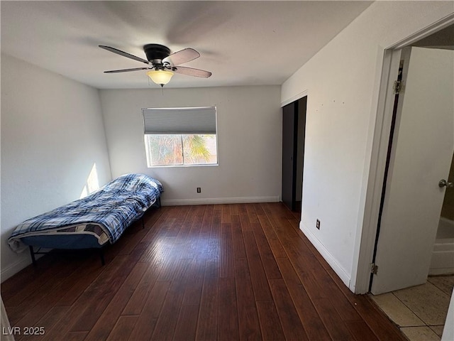 unfurnished bedroom featuring a ceiling fan, baseboards, and wood-type flooring