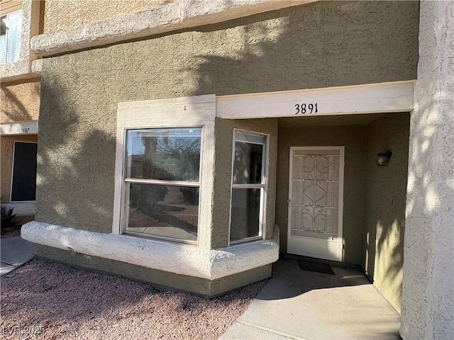 entrance to property with stucco siding