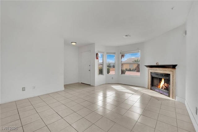 3891 Terrazzo Ave, Las Vegas, NV 89115 - unfurnished living room featuring light tile patterned floors, a premium fireplace, and visible vents